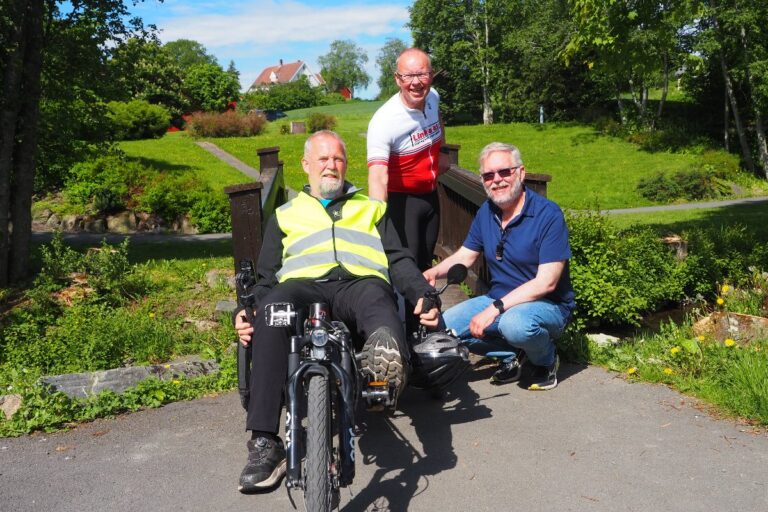 Tre menn som smiler til kamera