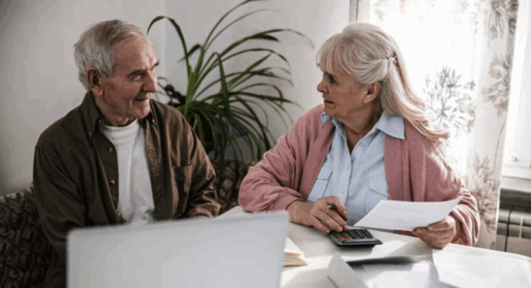 Kvinne og mann som snakker mens de ser på pc-en