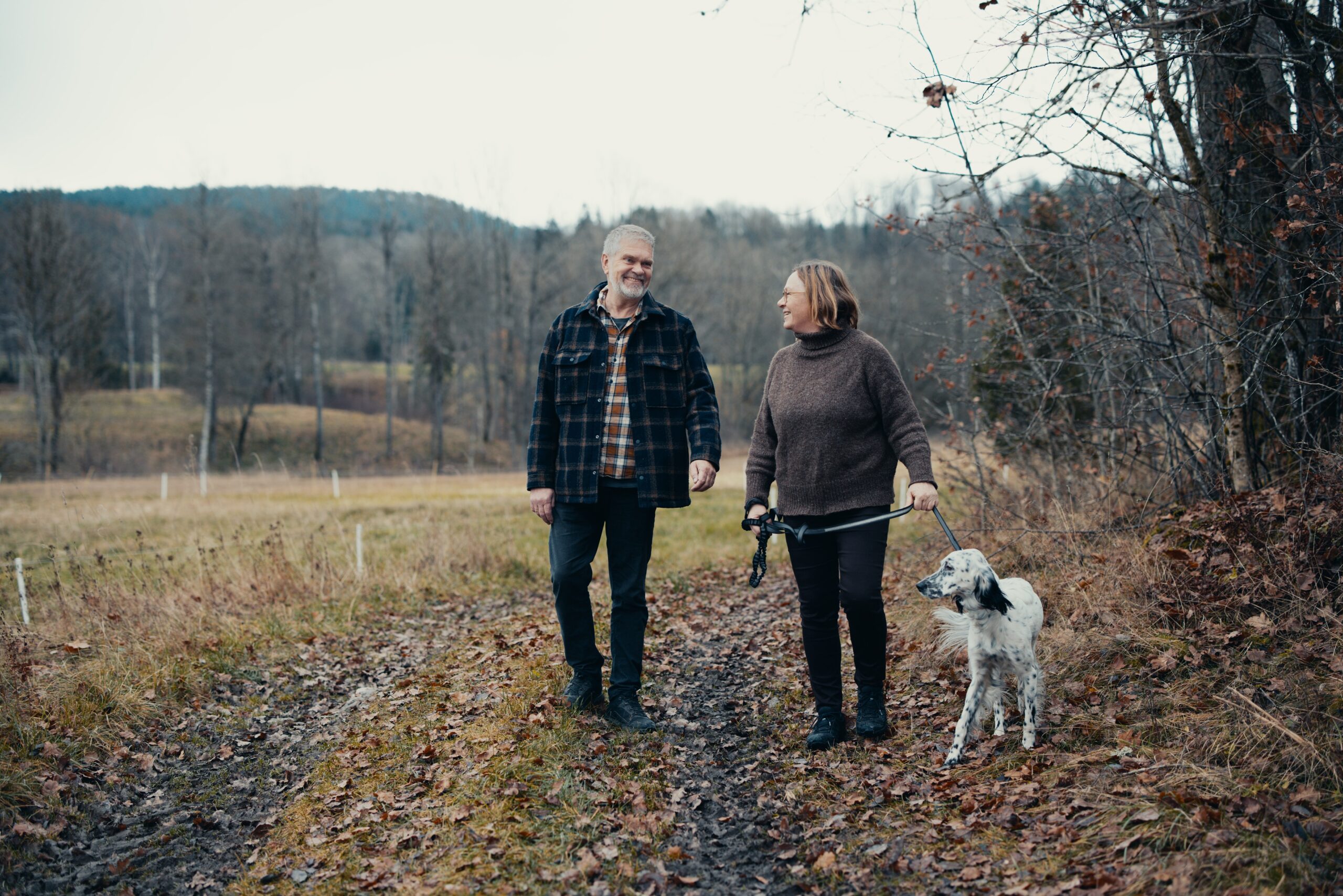 Terje og Ingvild går tur med hunden, de ser på hverandre og ser glade ut.